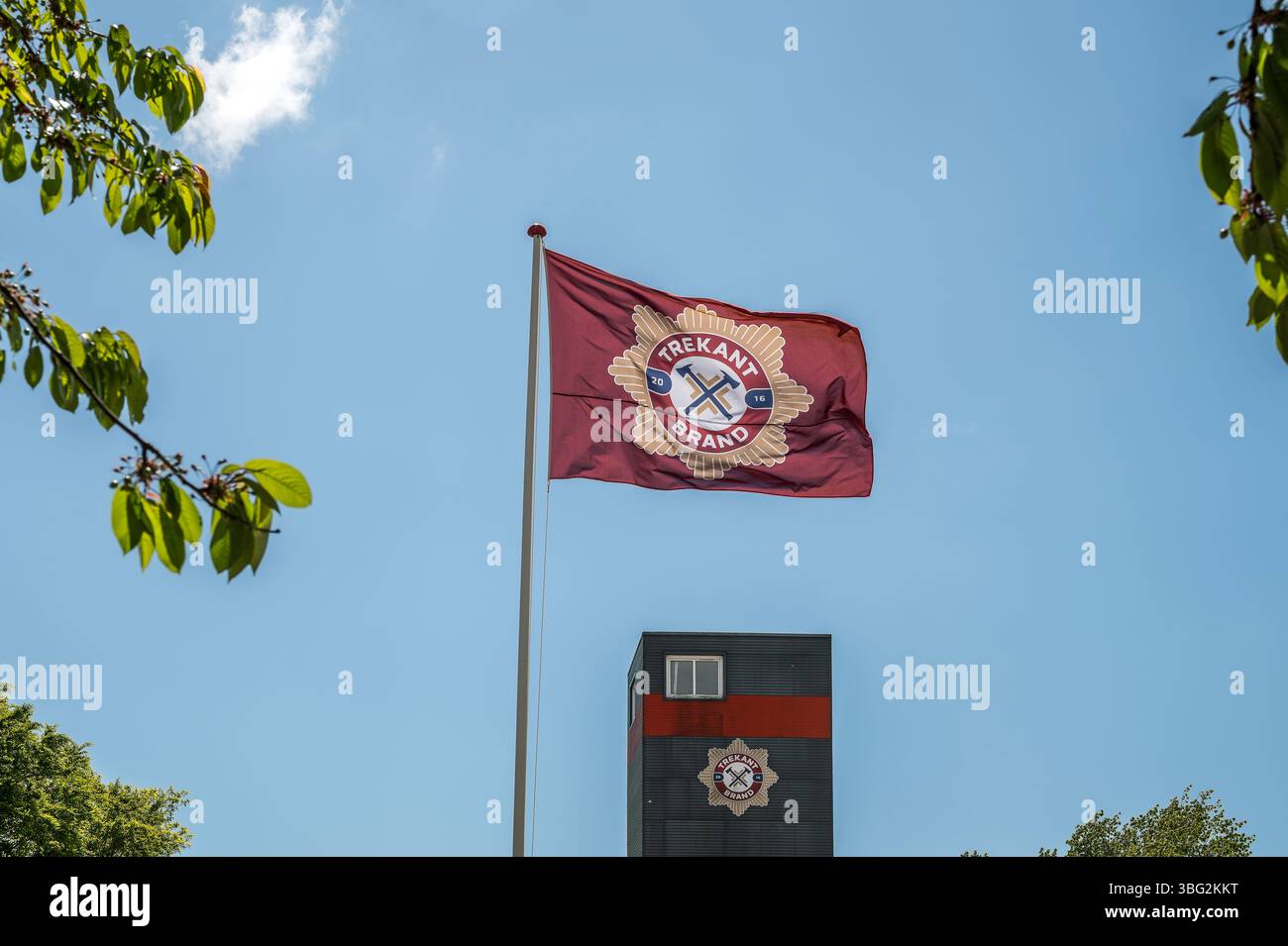 Flagge der Feuerwehrwehr, die im Wind fliegt, am 25. Mai 2025 auf dem Feuerwehrturm in Fredericia, Dänemark Stockfoto