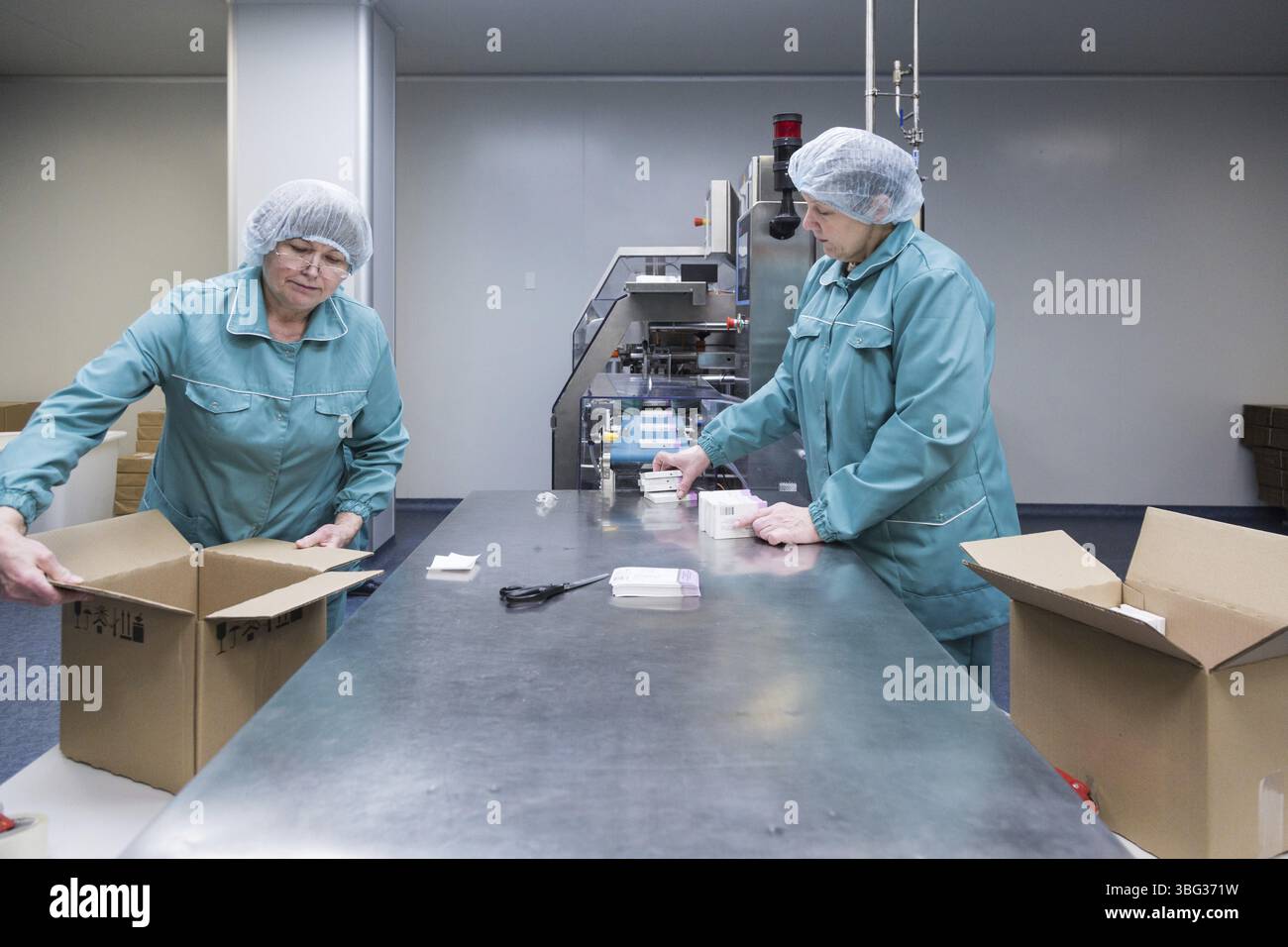 Pharmazeutische Techniker arbeiten in der Pharmafabrik unter sterilen Arbeitsbedingungen. Wissenschaftler tragen Schutzkleidung Stockfoto