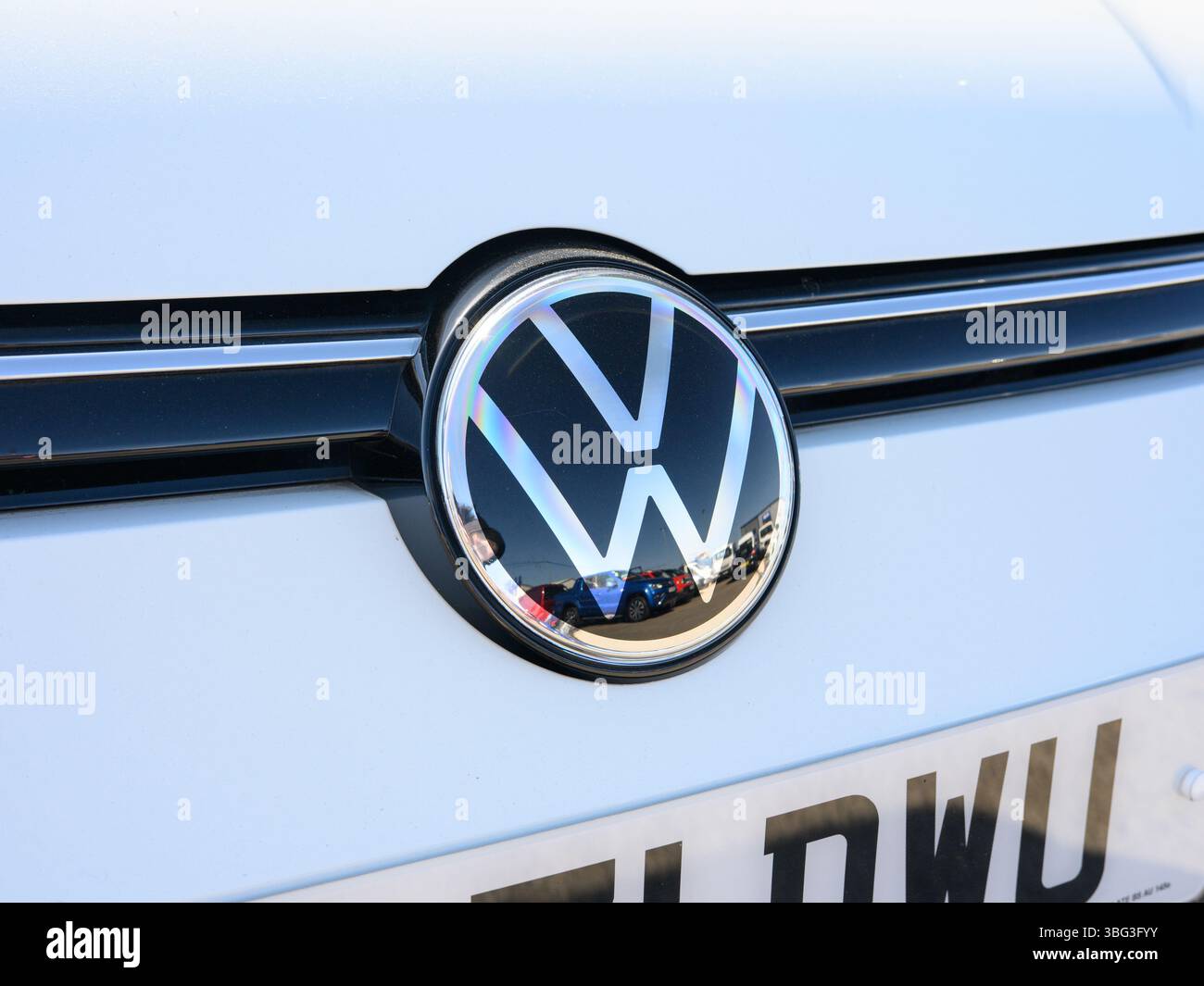 Dieses Bild zeigt eine Nahaufnahme des VW Golf Emblems auf der Außenseite des Fahrzeugs und hebt das ikonische Volkswagen Logo und das Modellbranding in einem sauberen, Stockfoto