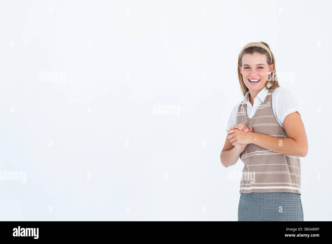 Lächelnde Frau, die Hände auf Brusthöhe im Studio vor weißem Hintergrund, Kopierraum Stockfoto