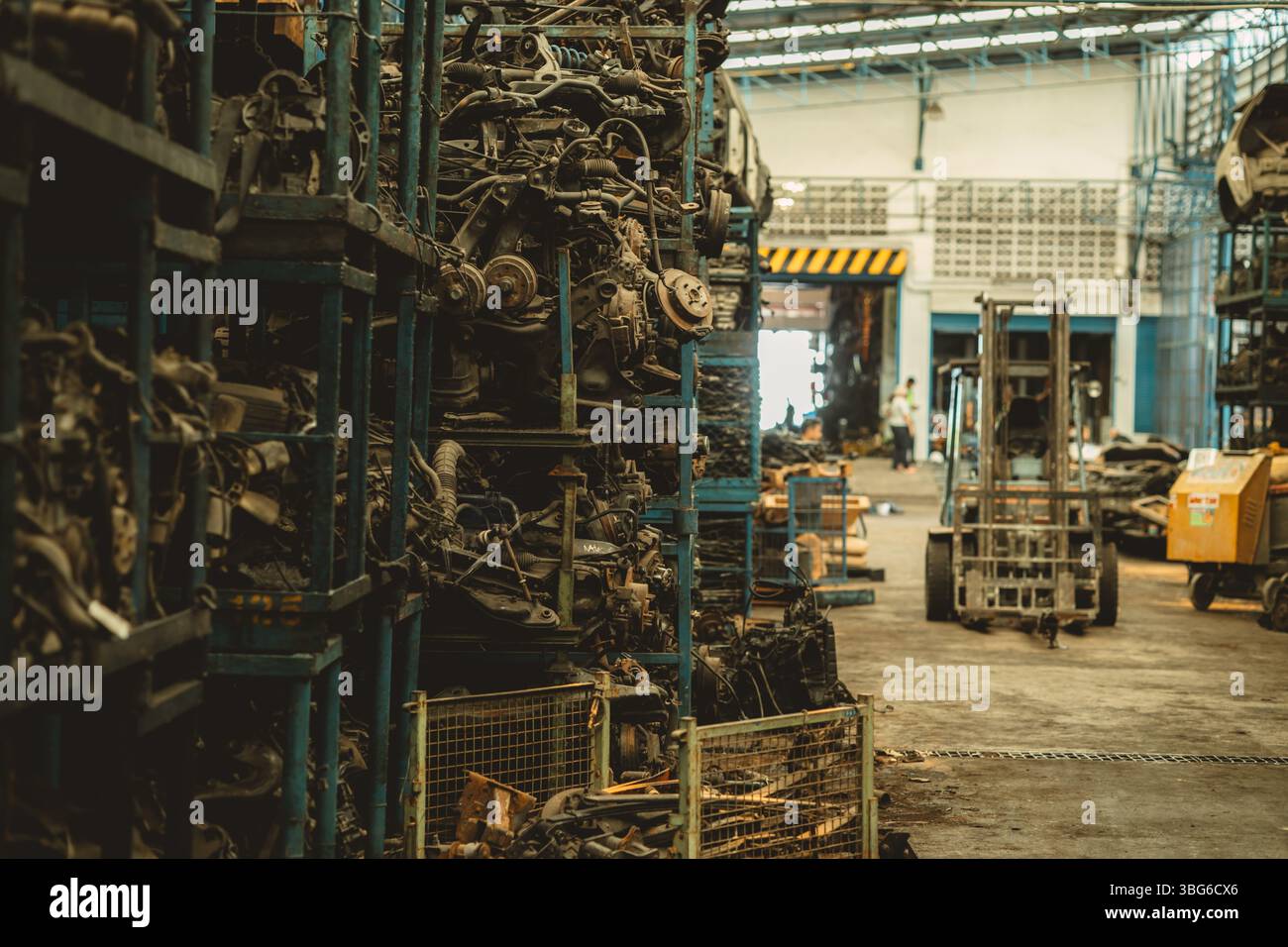 Lagerbestand alter Gebrauchtwagenteile in der Garage. Mitarbeiter, die in der Verwaltung von Autoteilen für Recyclingmotoren arbeiten. Stockfoto