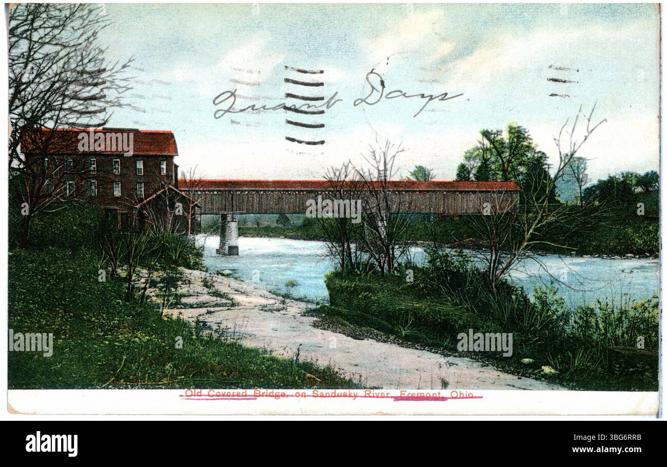 Dieses Bild aus dem Jahr 1907 zeigt die alte überdachte Brücke über den Sandusky River in Fremont, Ohio, mit einer Mühle in der Nähe. Das Foto zeigt die historische Infrastruktur des frühen 20. Jahrhunderts. Stockfoto