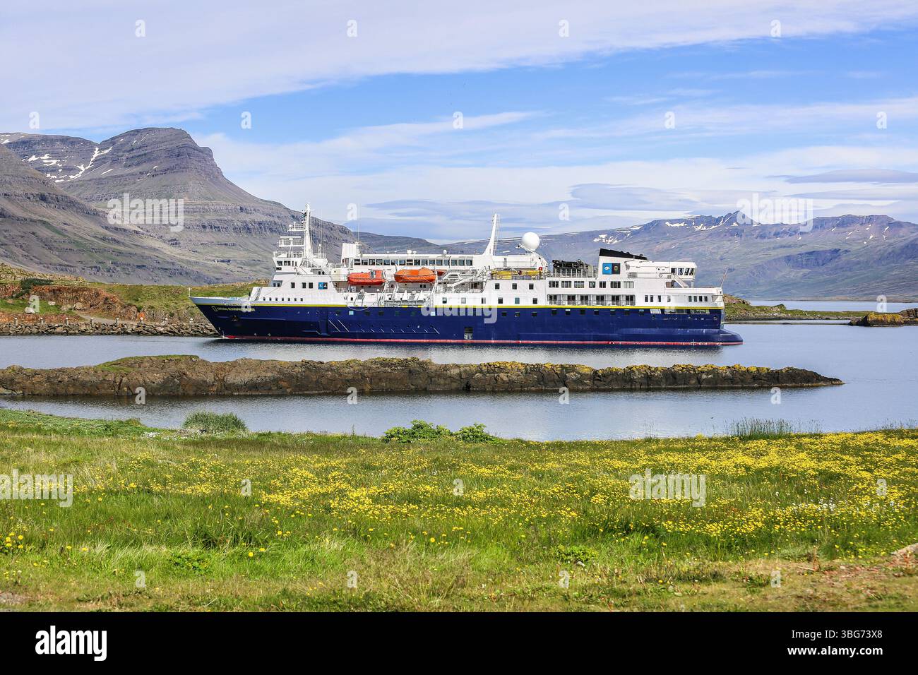 Das kleine Expeditionsschiff NATIONAL GEOGRAPHIC EXPLORER besucht das kleine Küstendorf Djúpivogur, Island, die bergige Fjordlandschaft Stockfoto