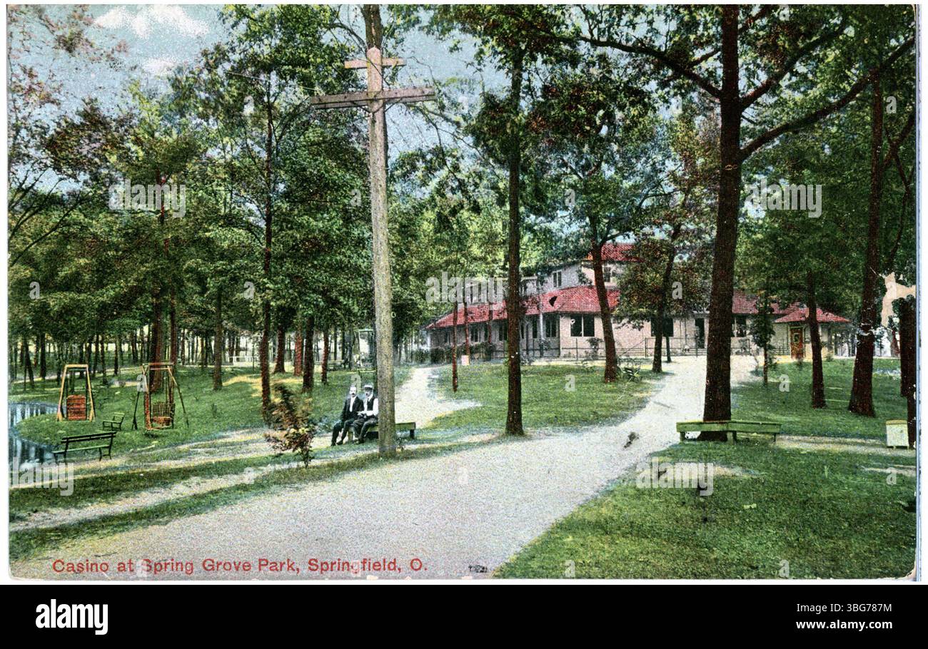 Dieser farbige Druck von 1909 zeigt das Casino im Spring Grove Park in Springfield, Ohio, umgeben von einem bewaldeten Park mit einem großen Backsteingebäude im Hintergrund. Stockfoto