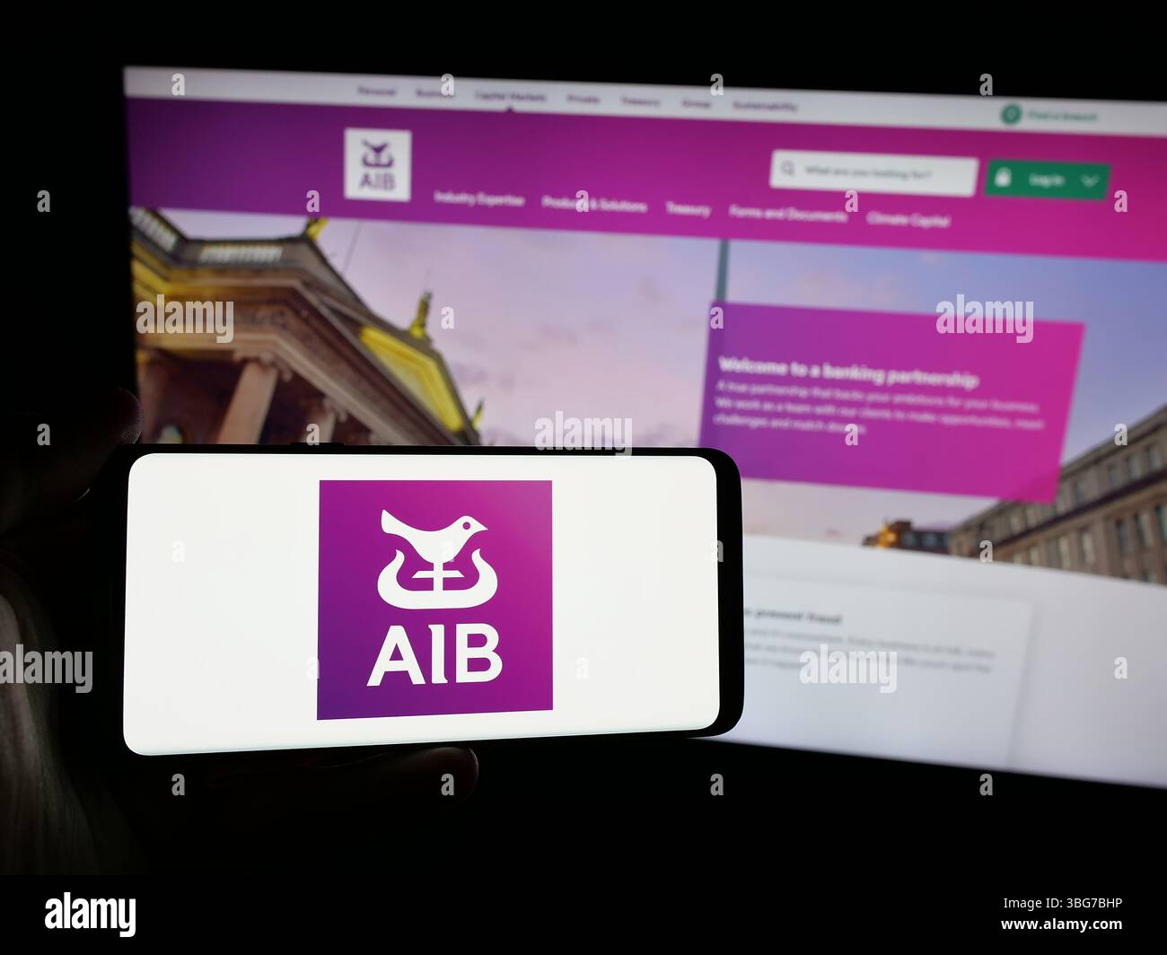 Stuttgart, Deutschland - 28.01.2025: Person, die ein Smartphone mit dem Logo des Finanzunternehmens Allied Irish Banks plc (AIB) auf dem Bildschirm vor der Website hält. Stockfoto