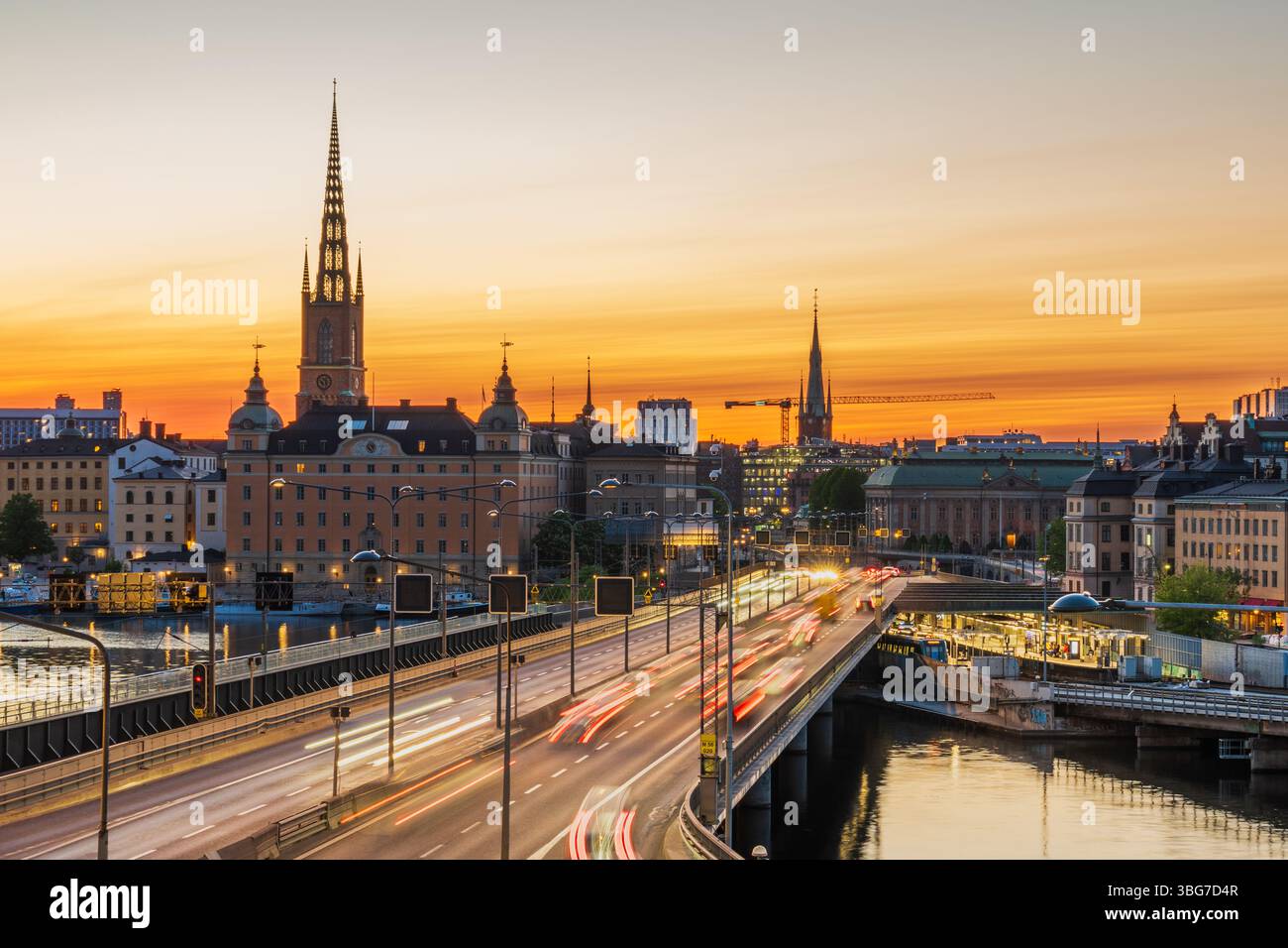 Stockholm, Schweden, Autos, die in der Abenddämmerung auf der Mittelbrücke in Richtung Altstadt vorbeifahren, lange Spur der Lichter. Stockfoto