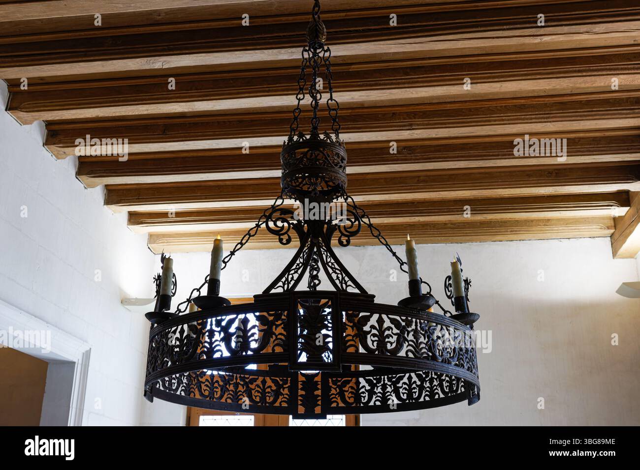 Château von Clos Lucé, Frankreich - 23.5,2025: Kunstvoller Kronleuchter aus Schmiedeeisen mit Kerzenlichtern Stockfoto