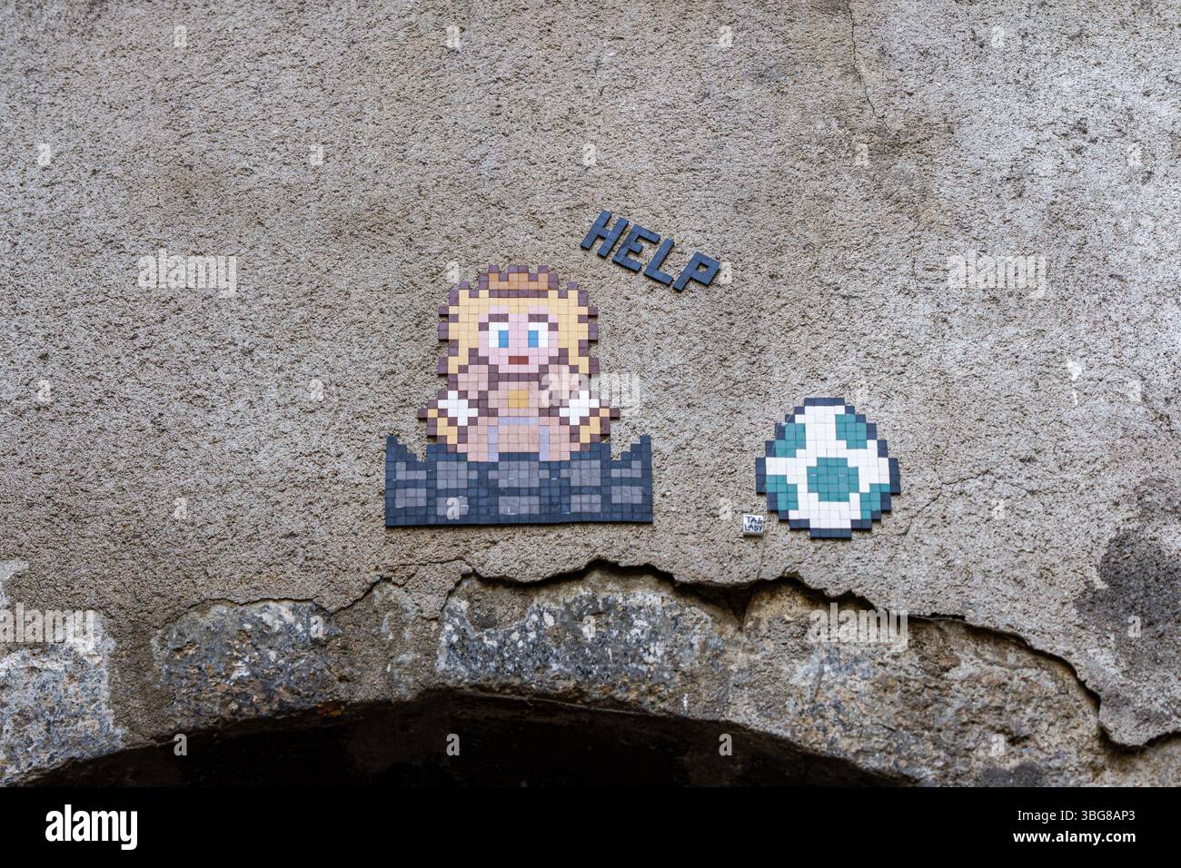 Pixelgrafik eines Mario-Charakters und eines Fußballs auf einer strukturierten Wand, mit dem Wort „HILFE“. Stockfoto