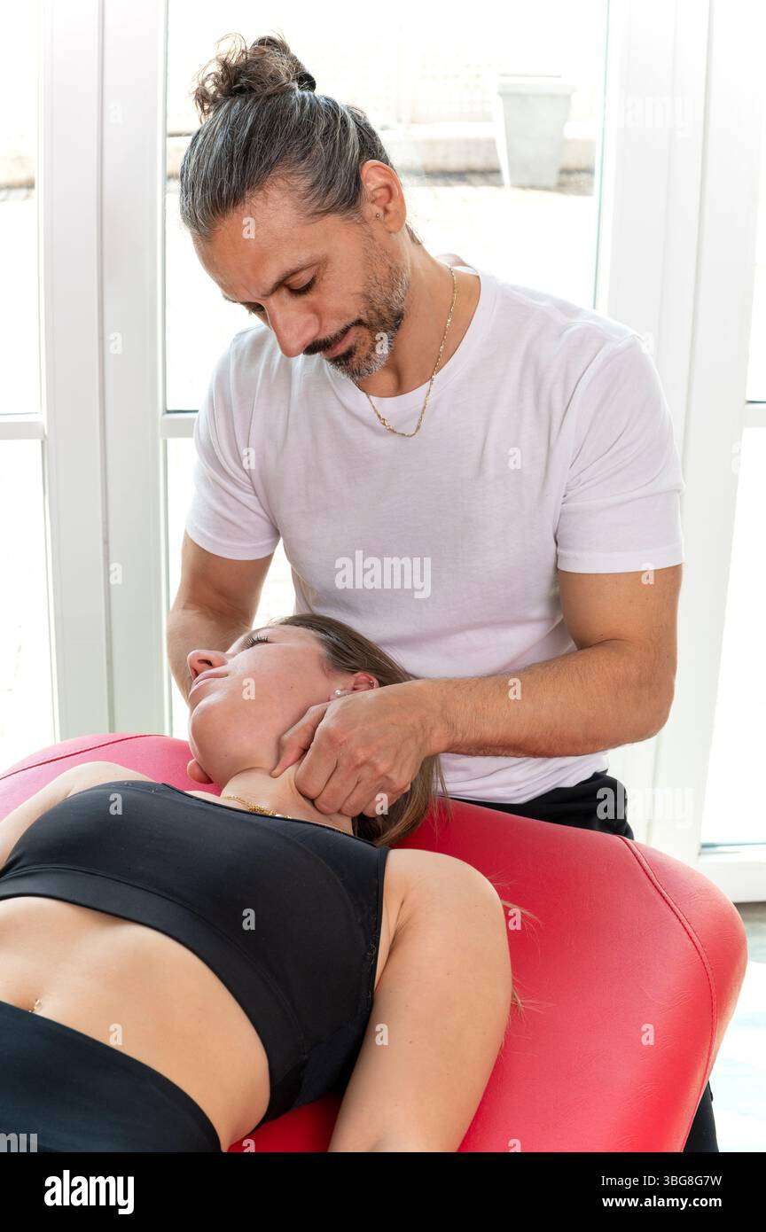 Osteopath zur Behandlung von Nackenschmerzen mit myofaszialer Freisetzungstechnik im klinischen Umfeld Stockfoto