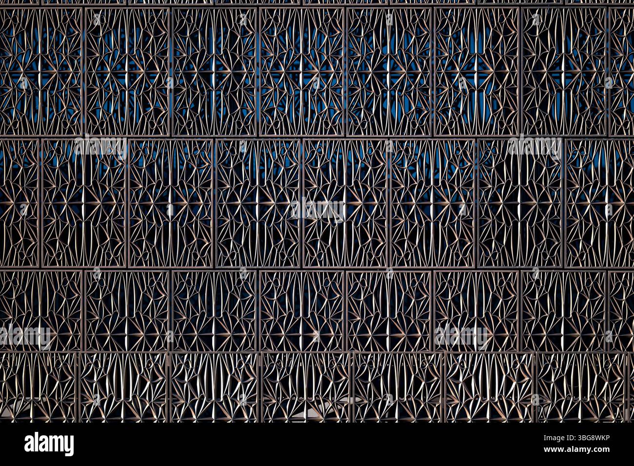 WASHINGTON DC – Detail der markanten bronzefarbenen, gemusterten Metalltafeln, die das „Corona“-Äußere des Smithsonian National Museum of African American History and Culture in der National Mall bilden. Diese perforierten Aluminiumplatten wurden vom führenden Architekten David Adjaye entworfen und sind von den ornamentalen Eisenarbeiten inspiriert, die von versklavten afroamerikanischen Handwerkern im Süden geschaffen wurden. Das Museum, das im September 2016 eröffnet wurde, verfügt über 3.600 dieser dekorativen Tafeln, die gefiltertes Licht hereinlassen und gleichzeitig Schatten für die Innenräume bieten. Stockfoto