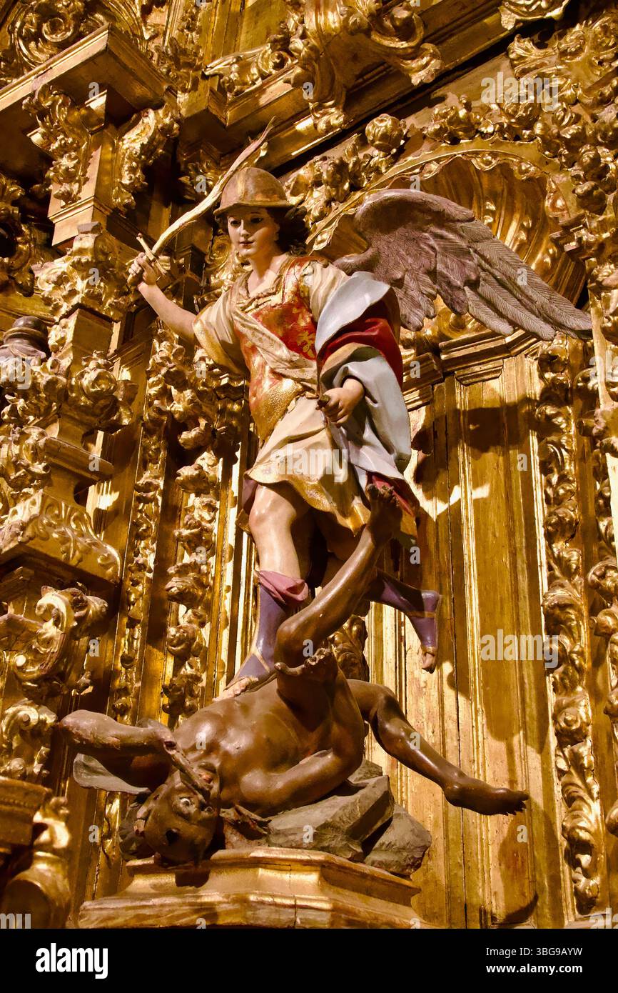 Eine Skulptur des Heiligen Michael, die ein Schwert auf Feuer schwindet, steht über dem Teufel in der Capilla de San Miguel Cáceres Co-Kathedrale der Heiligen Maria Caceres Spanien Stockfoto