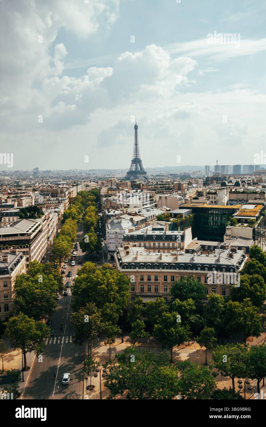 Der ikonische Eiffelturm erhebt sich über dem weitläufigen Stadtbild von Paris unter einem bewölkten Himmel. Stockfoto