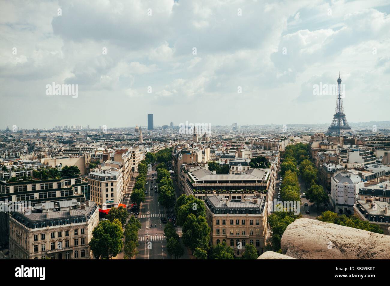 Der ikonische Eiffelturm erhebt sich über dem weitläufigen Stadtbild von Paris unter einem bewölkten Himmel. Stockfoto