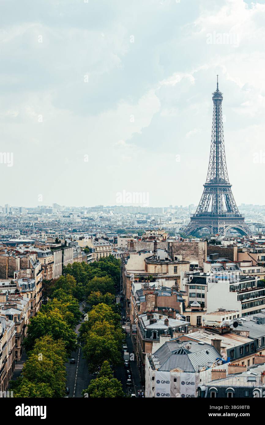 Der ikonische Eiffelturm erhebt sich über dem weitläufigen Stadtbild von Paris unter einem bewölkten Himmel. Stockfoto