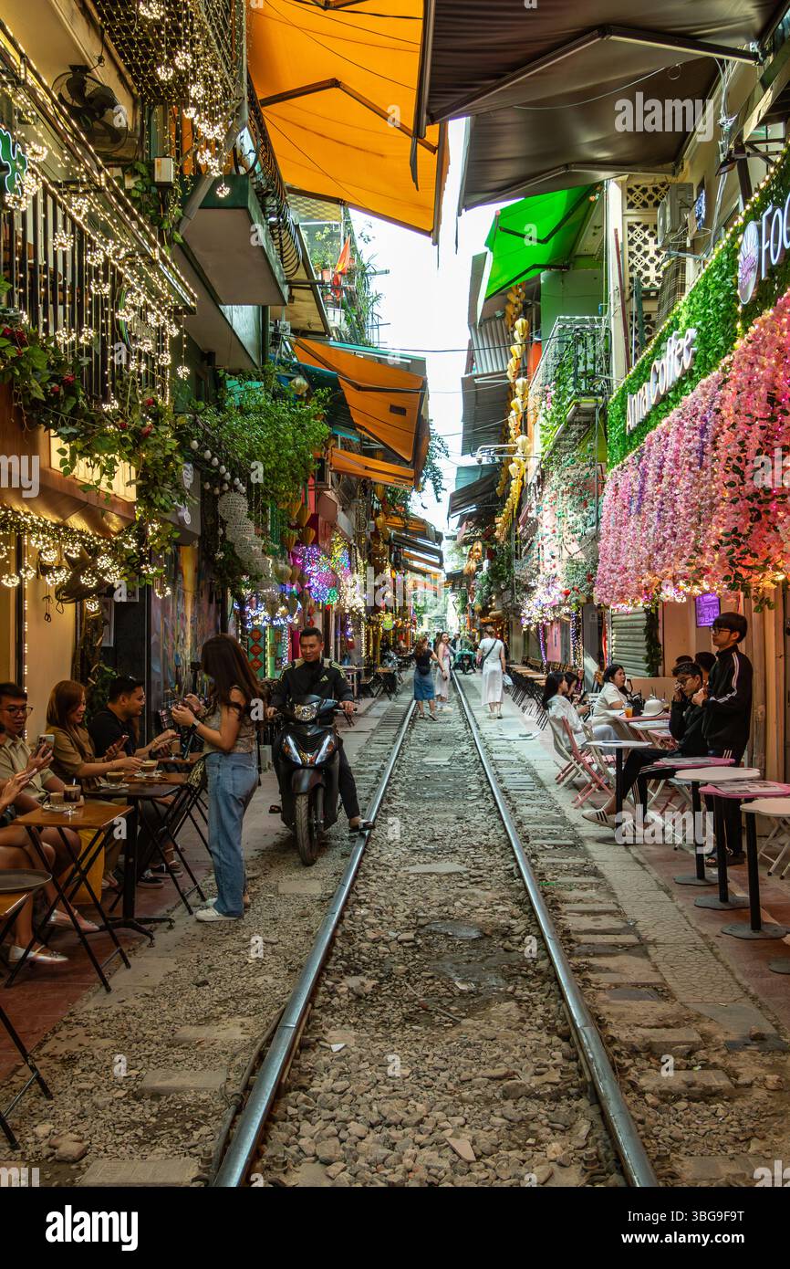 Moped vorbei an einem Café auf der Train Street in Hanoi Stockfoto