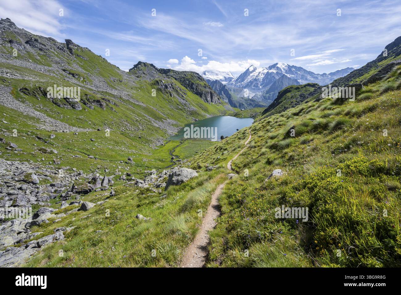 Wanderweg in einer malerischen Berglandschaft, Blick auf den Lac du Louvie Bergsee und Gletschergipfel des Grand Combine, Wallis Al Stockfoto