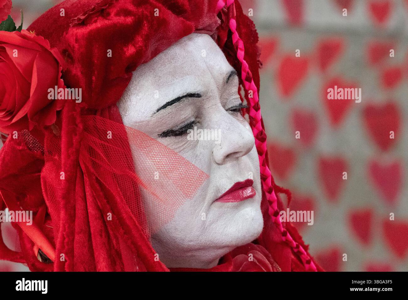 London, Großbritannien. 4. Juni 2025. Die Aktivistentruppe der Roten Rebellen-Brigade läuft entlang der Nationalen COVID-Mauer, gegenüber den Houses of Parliament, schließt sich palästinensischen Anhängern an, die das Parlament umgeben, und bildet eine "Rote Linie für Palästina", um die britische Regierung aufzufordern, Israels Krieg gegen Gaza zu unterstützen und stattdessen ein Waffenembargo und Sanktionen gegen Israel durchzusetzen. Die Veranstaltung erstreckte sich über Westminster und Lambeth Bridge, als Sir Keir Starmer Fragen des Premierministers im Unterhaus stellte. Quelle: Ron Fassbender/Alamy Live News Stockfoto