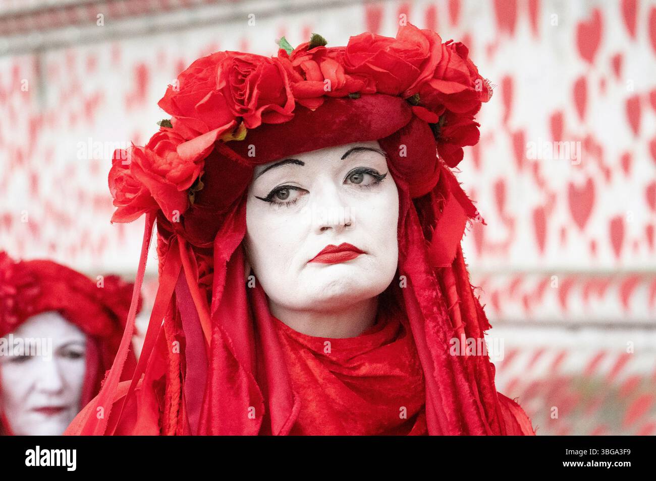 London, Großbritannien. 4. Juni 2025. Die Aktivistentruppe der Roten Rebellen-Brigade läuft entlang der Nationalen COVID-Mauer, gegenüber den Houses of Parliament, schließt sich palästinensischen Anhängern an, die das Parlament umgeben, und bildet eine "Rote Linie für Palästina", um die britische Regierung aufzufordern, Israels Krieg gegen Gaza zu unterstützen und stattdessen ein Waffenembargo und Sanktionen gegen Israel durchzusetzen. Die Veranstaltung erstreckte sich über Westminster und Lambeth Bridge, als Sir Keir Starmer Fragen des Premierministers im Unterhaus stellte. Quelle: Ron Fassbender/Alamy Live News Stockfoto