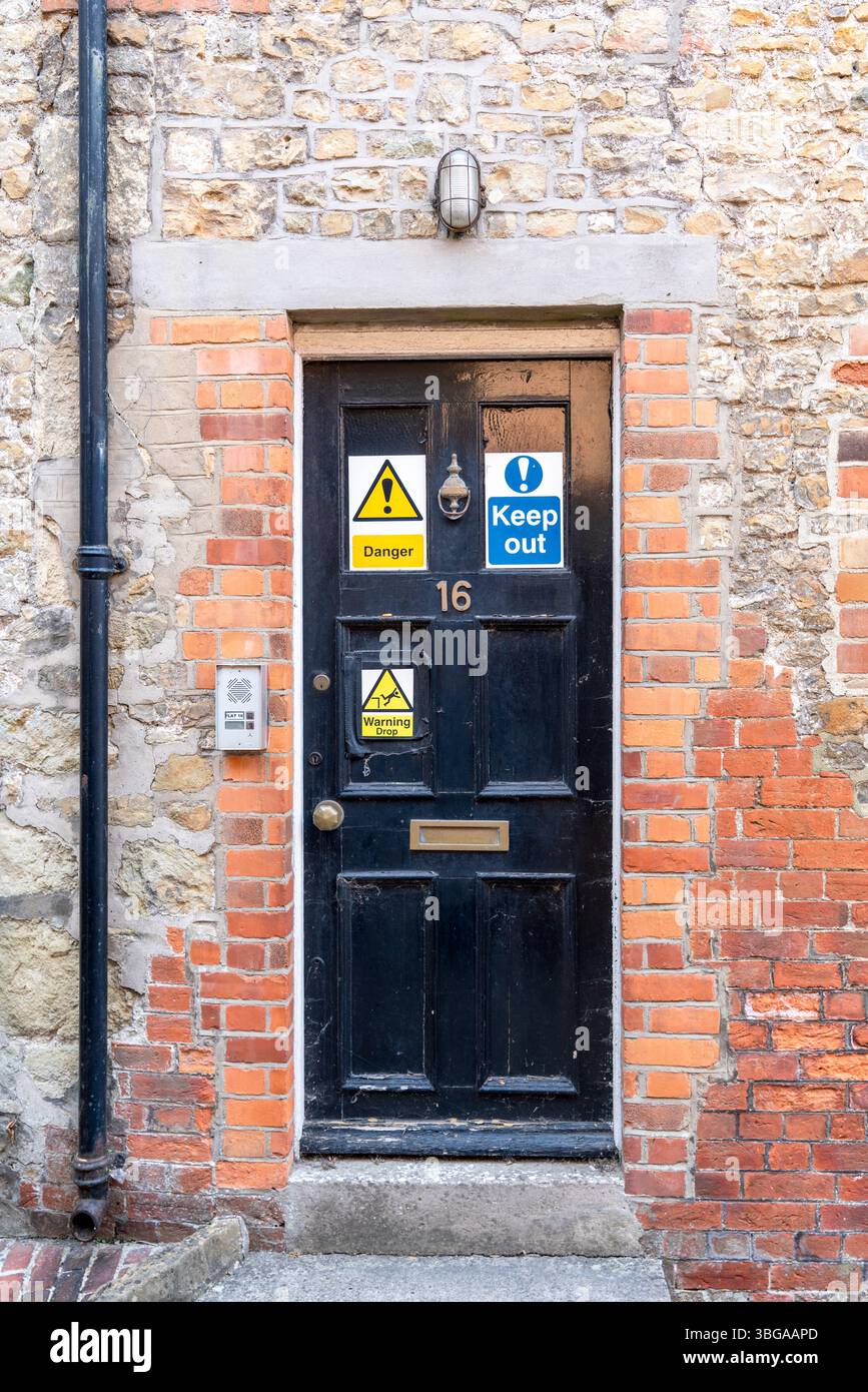 Schwarze Tür mit abnehmenden Schildern Stockfoto