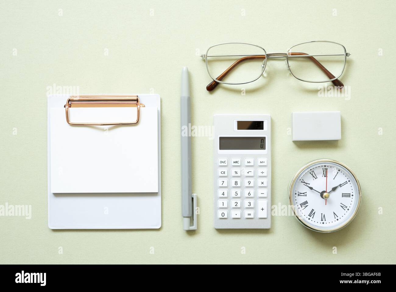 Klemmbrett, Stift, Uhr, Brille, Taschenrechner, Radierer auf mintfarbenem Schreibtischhintergrund. Untersuchung und Arbeitsbereich. Flach liegend, Draufsicht, Kopierbereich Stockfoto