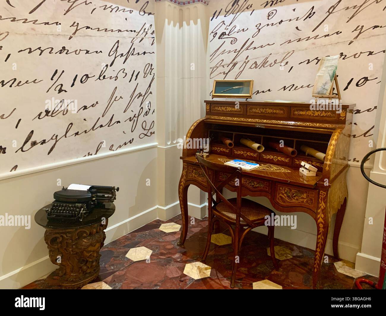 Der wunderschöne antike Schreibtisch befindet sich unter einer übergroßen Kalligrafie-Wand im skurrilen Kuriositätenkabinett des Ortea Palace Hotels. Stockfoto
