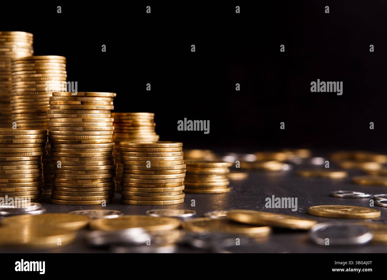 Wachsende Säulen von Goldmünzen auf dem Tisch Stockfoto