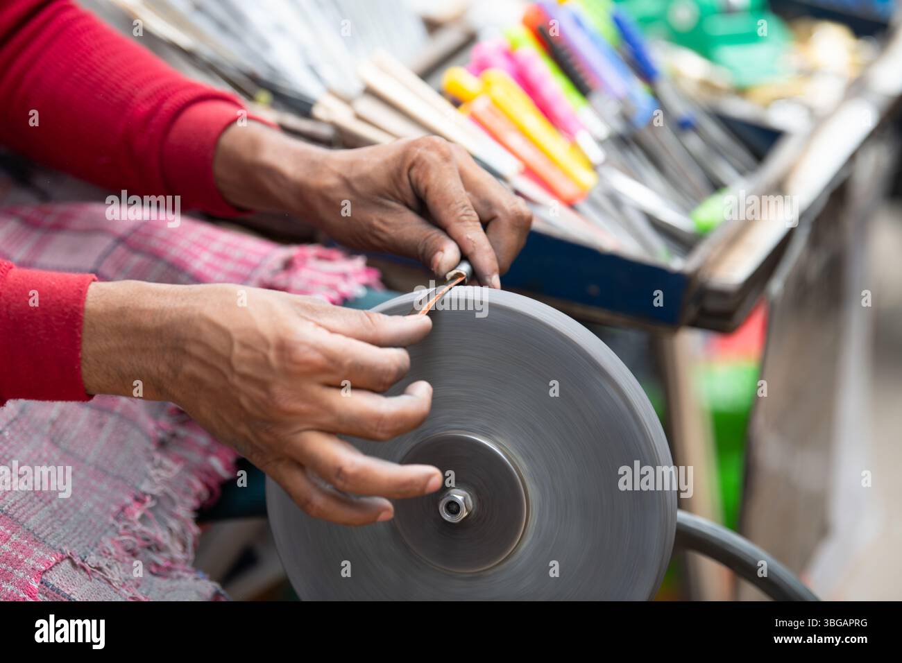 Schärfmesser Klinge auf Einem Schleifstein, indischer Messerschärfer bei der Arbeit, Rad über Pedale angetrieben, Kultur Indiens Stockfoto