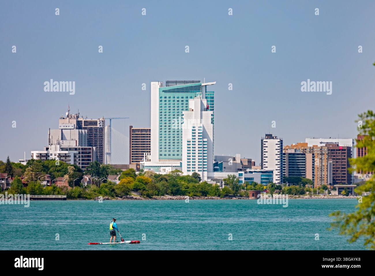 Detroit, Michigan - Ein Mann paddelt im Detroit River. Windsor, Ontario, liegt auf der anderen Seite des Flusses. Stockfoto