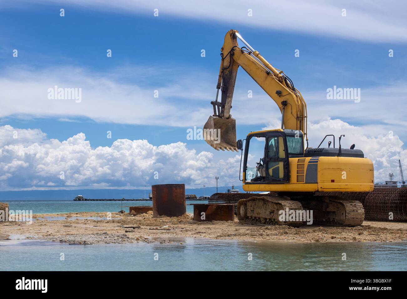 Ein Bagger baut eine Brücke über Wasser. Ein sonniger Tag Stockfoto