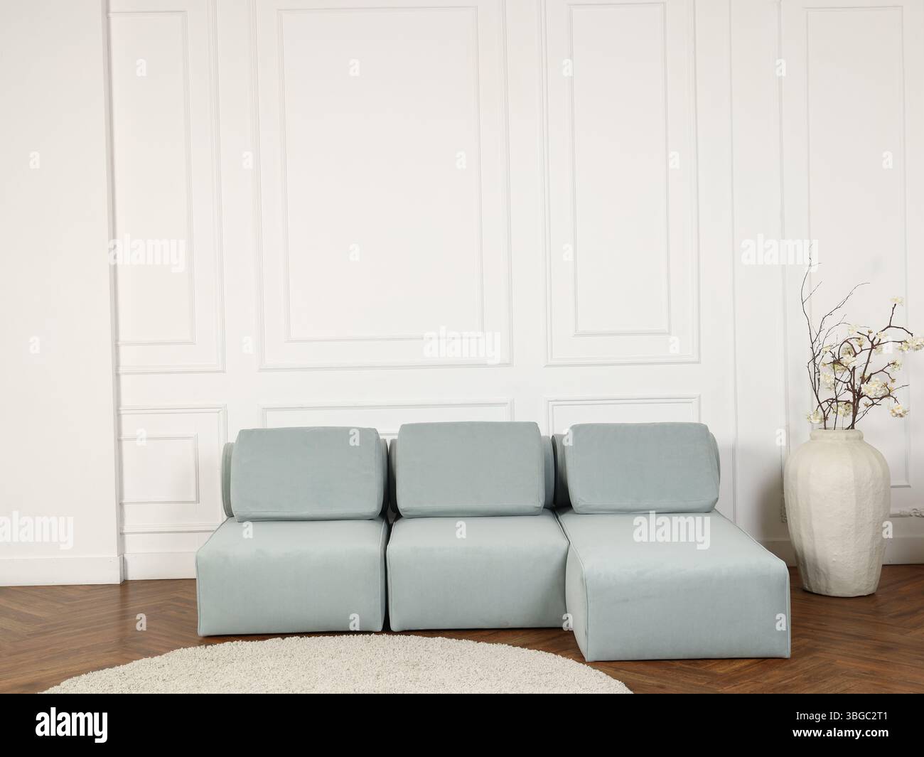 Entdecken Sie ein modernes minimalistisches Sofa, das in ruhigen Blautönen für Ihr Zuhause sorgt Stockfoto
