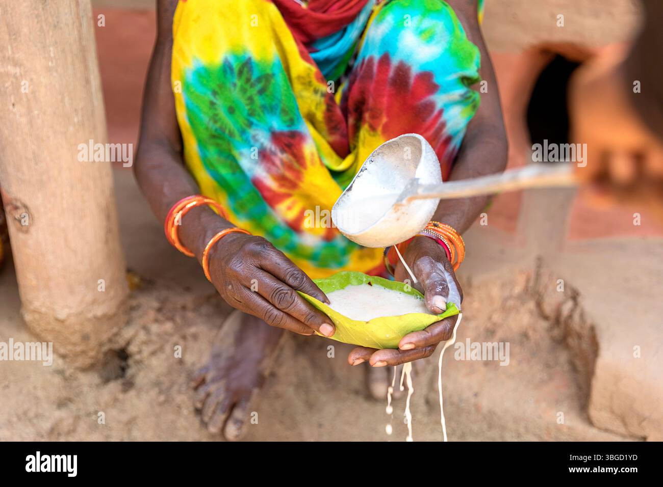 Ein einheimischer Schaman serviert Hochzeitsgästen alkoholische Getränke auf einer traditionellen Stammeshochzeit in orissa in indien Stockfoto