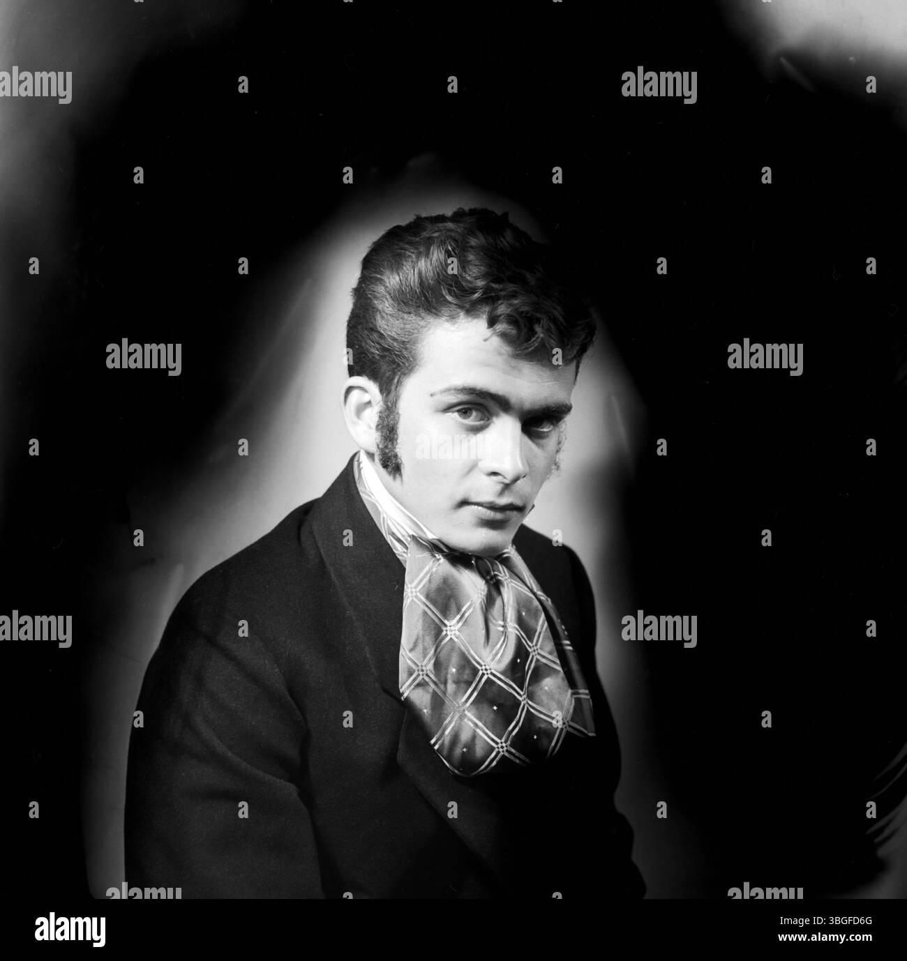 Porträt des jungen Klaus Redenbacher in historischer Theaterkostümierung mit Koteletten und voluminösem Halstuch, aufgenommen in München, 1956. Stockfoto