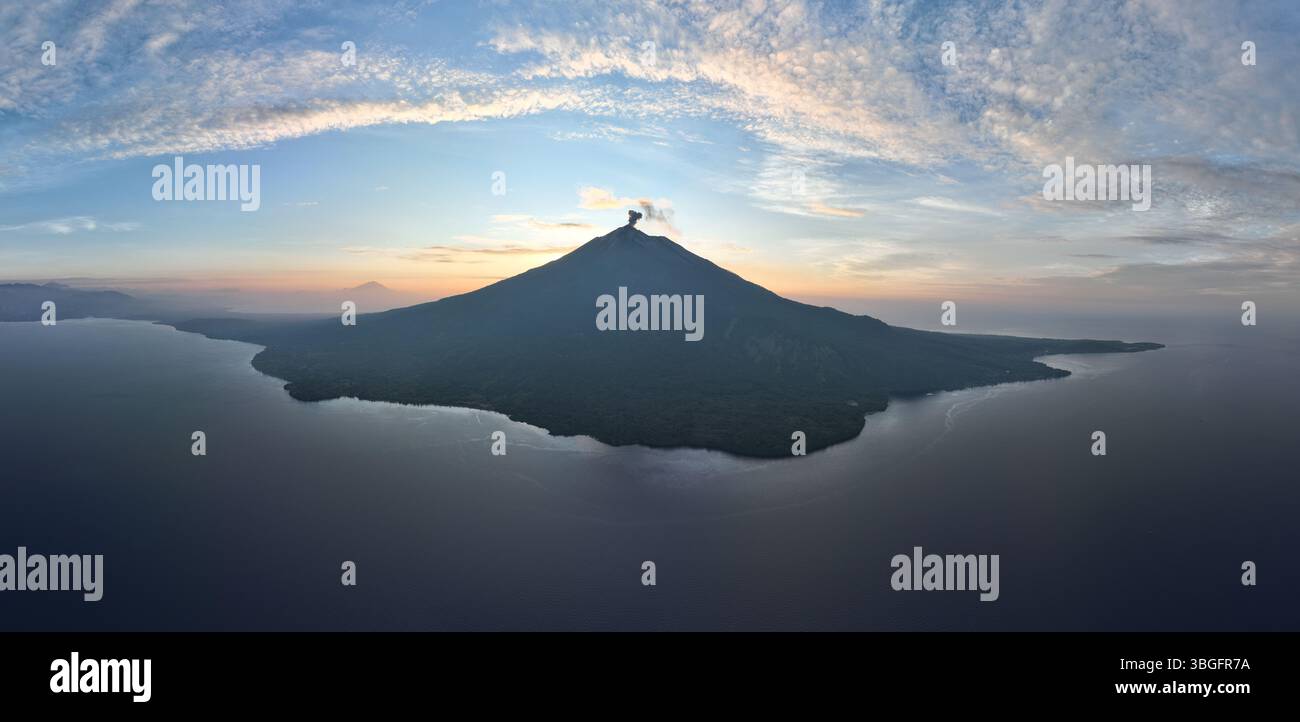 Sonnenuntergang Silhouetten Iliape Vulkan auf der Insel Lembata auf den Kleinen Sunda-Inseln Indonesiens. Dieser malerische Vulkan war in letzter Zeit extrem aktiv. Stockfoto