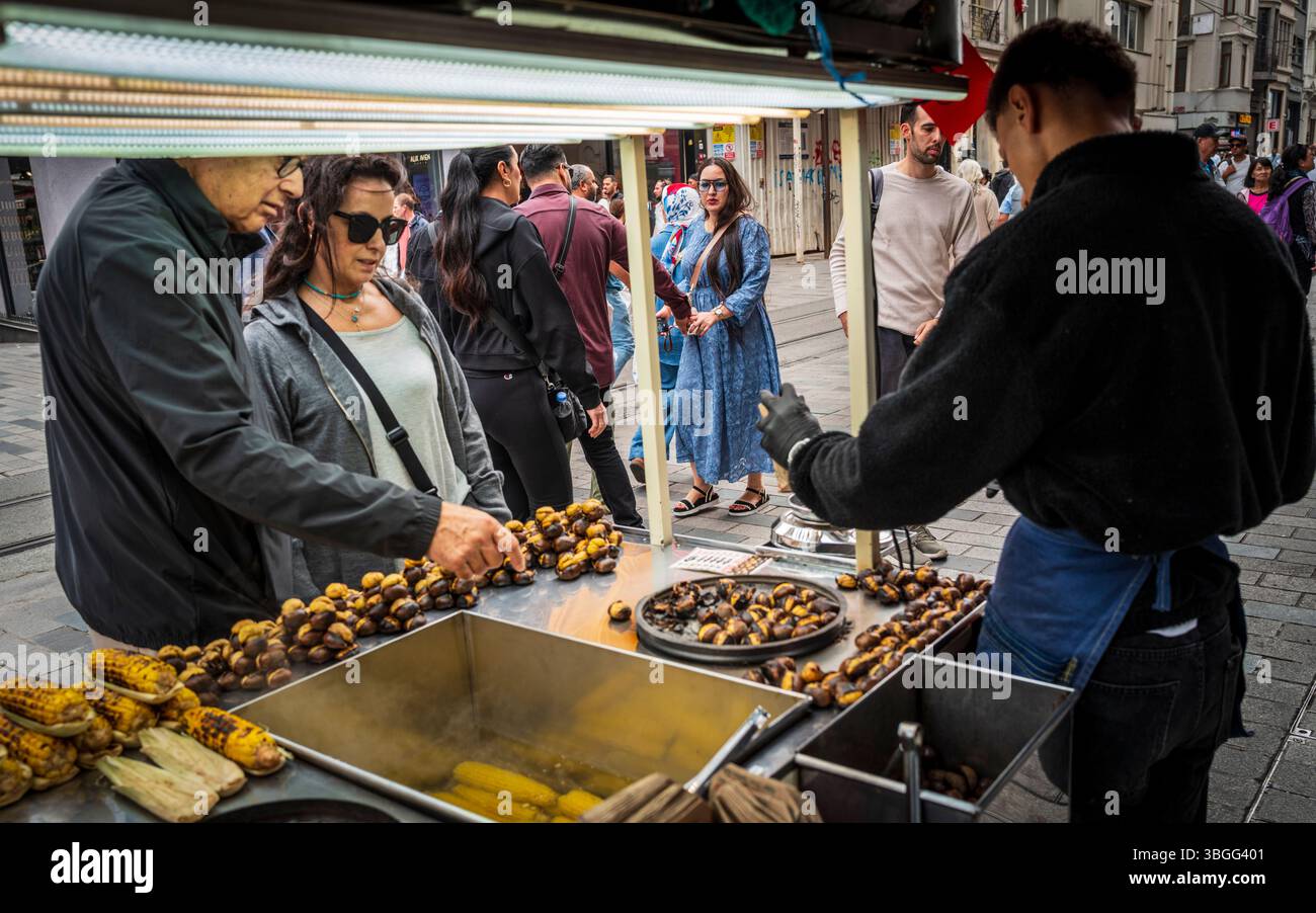 Mann, der Kastanien und Mais verkauft, von einem mobilen Stand in der Istiklal-Straße, Istanbul, Türkei Stockfoto