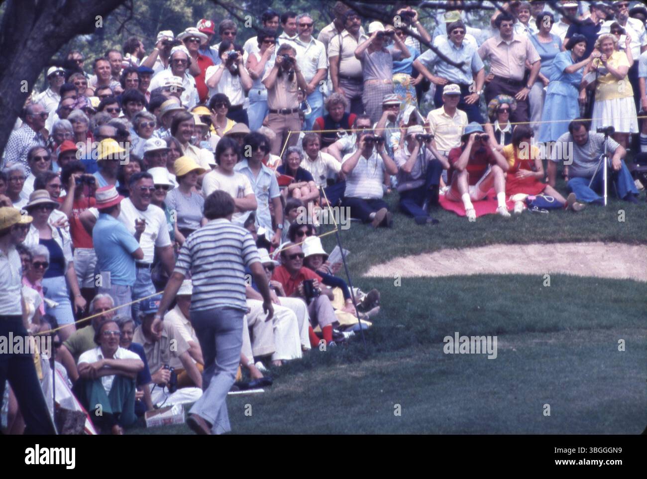 Während des Memorial Tournament pro-am 1977 im Muirfield Village Golf Club versammeln sich Menschenmassen auf dem Green. Die Menschen nutzen Ferngläser und Kameras, um das Ereignis zu beobachten und festzuhalten. Stockfoto
