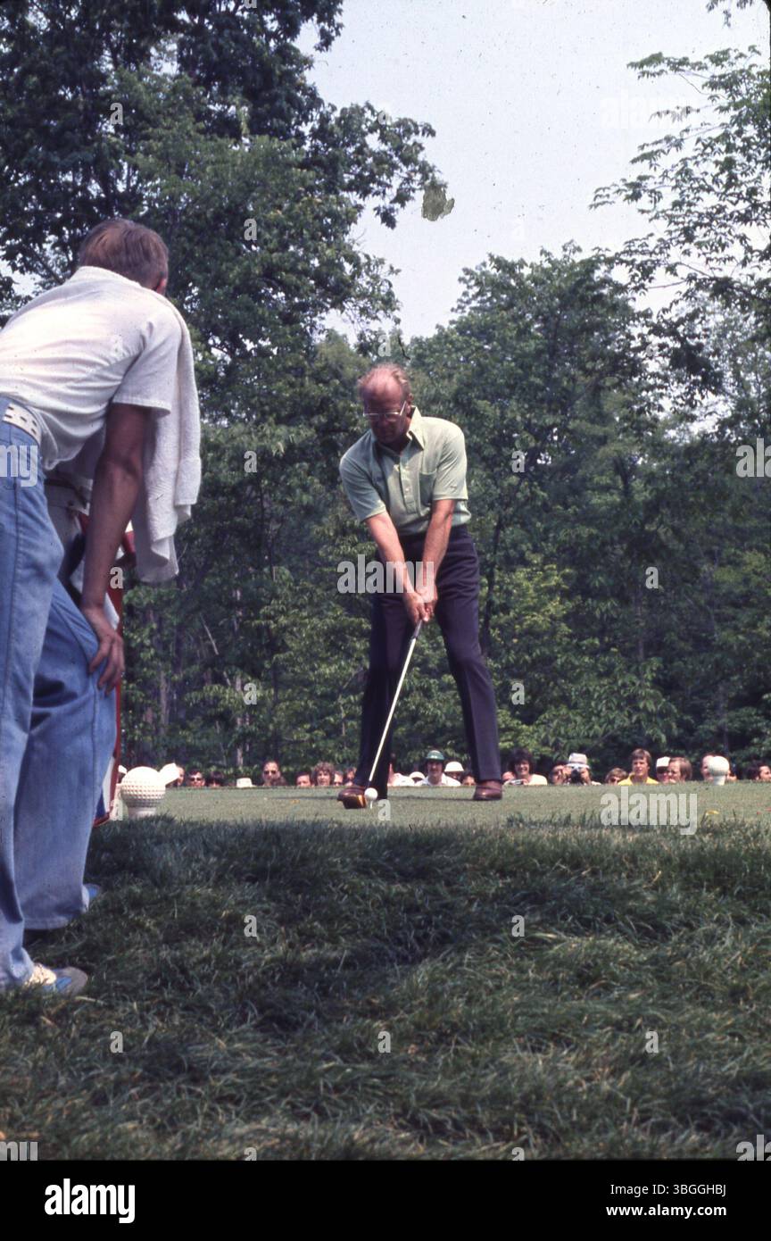 Der ehemalige Präsident Gerald Ford bereitet sich auf einen Abschlag während des Memorial Tournament Pro-am 1977 im Muirfield Village Golf Club vor. Er nahm an einem Sixsome Teil, zu dem die Golfspieler Jack Nicklaus und Roger Maltbie, die Schauspieler Bob Hope und Jackie Gleason sowie der Musiker Glen Campbell gehörten. Zuschauer beobachten die Veranstaltung. Stockfoto