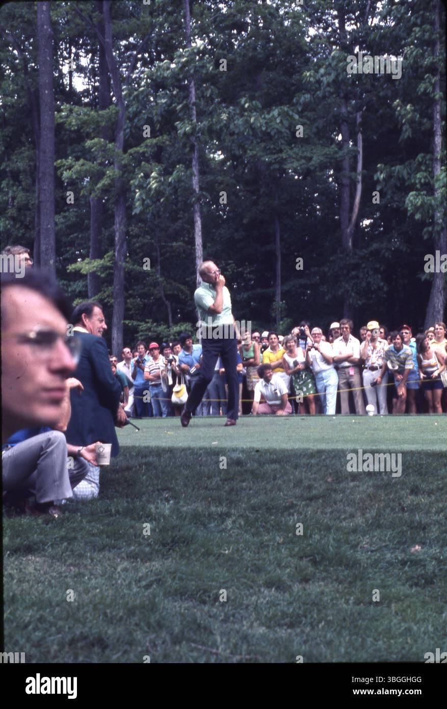 Der ehemalige Präsident Gerald Ford nimmt 1977 am Memorial Tournament pro-am im Muirfield Village Golf Club Teil. Ford schlägt während einer Runde mit den professionellen Golfern Jack Nicklaus, Roger Maltbie, dem Schauspieler Bob Hope, dem Komiker Jackie Gleason und dem Musiker Glen Campbell ab. Eine Menge Zuschauer umgibt das T-Stück. Stockfoto
