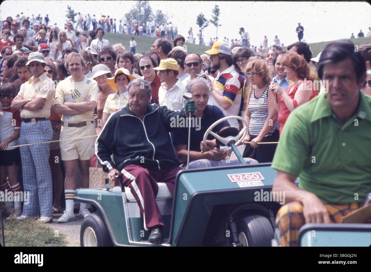 Auf diesem Foto aus dem Jahr 1977 sitzt der Komiker Jackie Gleason während des Memorial Tournament Pro-am im Muirfield Village Golf Club in einem Golfwagen. Gleason spielte neben dem ehemaligen Präsidenten Gerald Ford, den professionellen Golfern Jack Nicklaus und Roger Maltbie, dem Komiker Bob Hope und dem Musiker Glen Campbell. Stockfoto