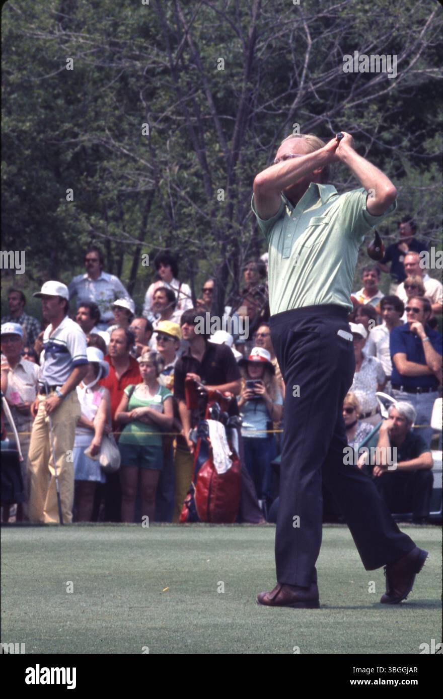 Der ehemalige US-Präsident Gerald Ford wird gesehen, nachdem er während des Memorial Tournament Pro-am 1977 im Muirfield Village Golf Club einen Golfschuss getroffen hat. Die Zuschauer beobachten den Flug des Balls. Stockfoto