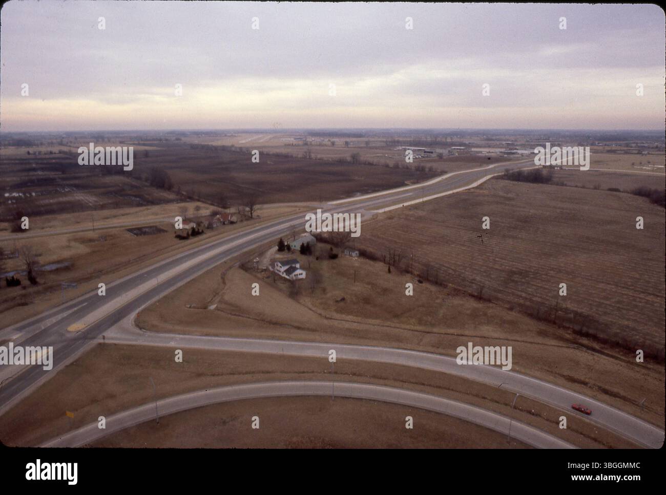 Eine Luftaufnahme der Georgesville Road im Februar 1981 mit Blick nach Süden über landwirtschaftliche Felder in der Nähe der Kreuzung I-270. Das Foto zeigt die Ausfahrt/Einstiegsrampen der I-270, die diagonal verlaufende Georgesville Road und die Landebahn von Bolton Field in der Ferne. Die Erschließung umfasst die Umzonierung von 57,5 Acres für die Herstellung, wie von der Entwicklungskommission empfohlen. Stockfoto
