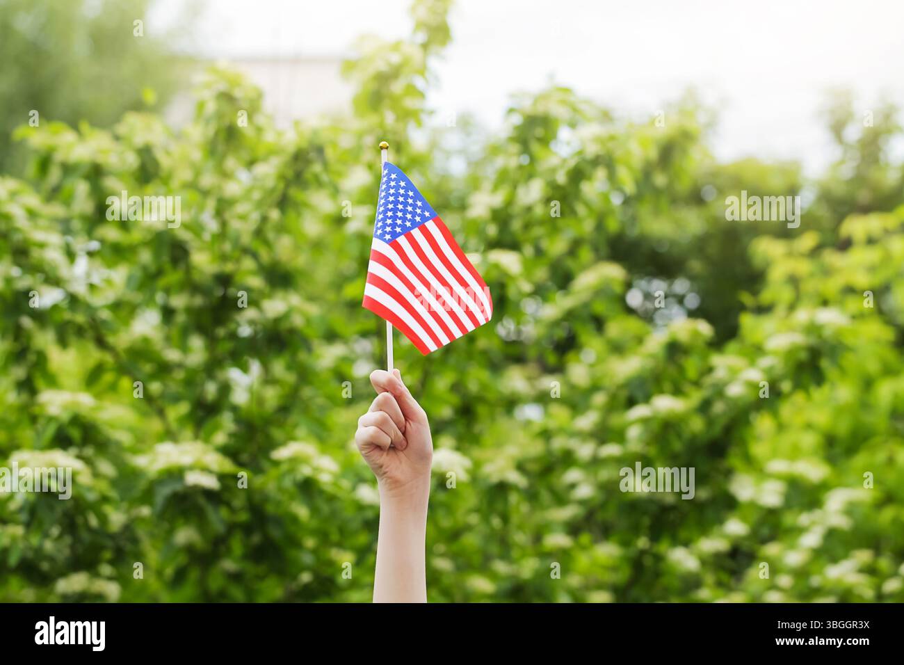 Mit einer amerikanischen Flagge auf der Parade zum Unabhängigkeitstag am 4. Juli Stockfoto