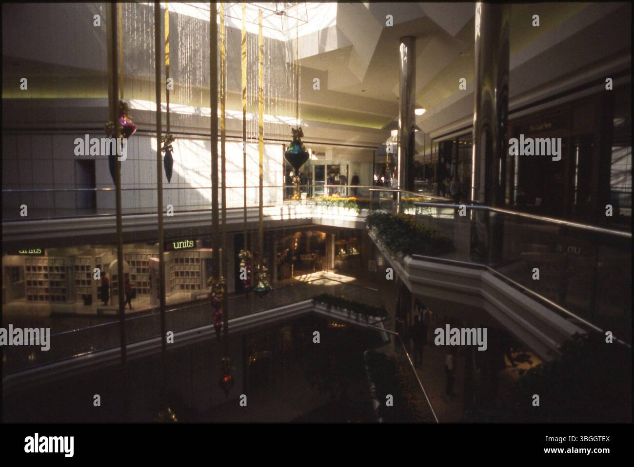 Innenansicht der Columbus City Center Mall, die am 18. August 1989 eröffnet und am 5. März 2009 geschlossen wurde. Das Bild zeigt ein Schild für Einheiten, eine Bekleidungskette und große Weihnachtsdekorationen, die von der Decke hängen. Stockfoto