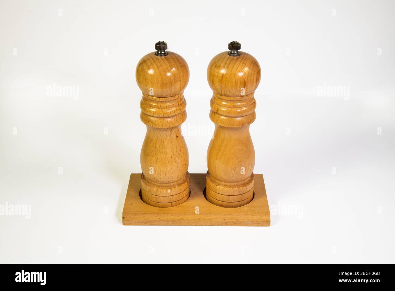Salz- und Pfeffermühlen aus Holz isoliert auf einem sauberen weißen Hintergrund, minimalistisches Küchenutenkonzept. Stockfoto