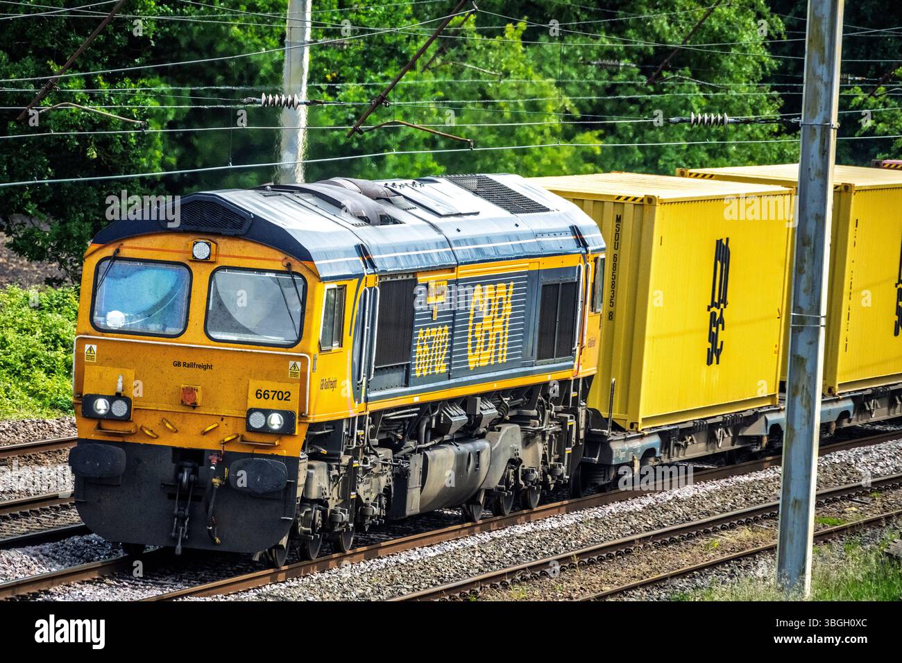 Die dieselelektrische Güterlokomotive der GBRf-Güterklasse 66 mit dem Namen Blue Lightning, die Container auf der Westküste-Hauptstrecke in Winwick transportiert. Stockfoto