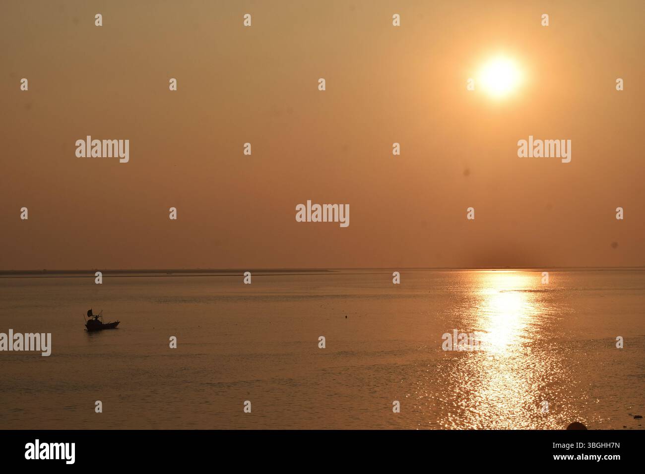 Die goldene Stunde auf dem Meghna River zeichnet ein ruhiges Bild von Fischern, die den Rhythmus der Natur umarmen. Stockfoto