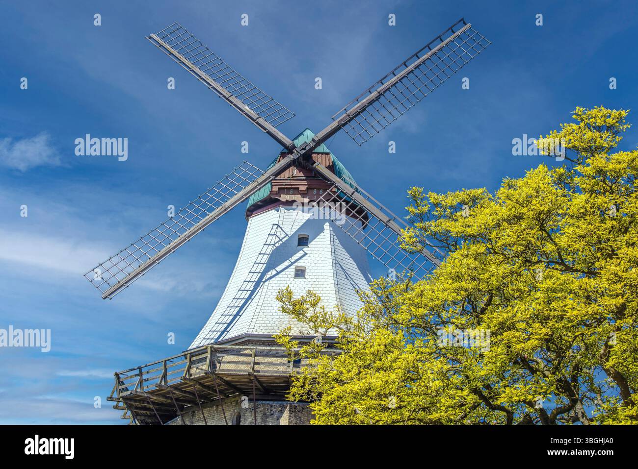 Historische deutsche Windmühle, die an einem hellen, sonnigen Tag in den Himmel streckt und traditionelle Architektur und Ingenieurskunst zeigt. Stockfoto