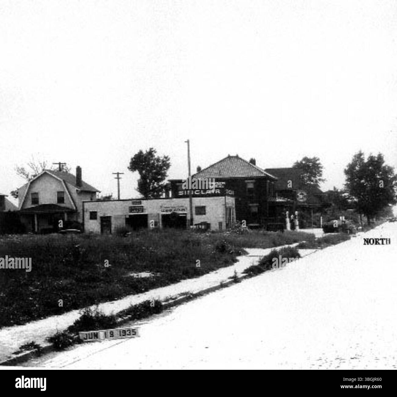 Dieses Foto aus dem Jahr 1935 von der West 5th Avenue in Fairview in Columbus, Ohio, zeigt die Sinclair Füllstation in #1589, mit nahe gelegenen Gebäuden wie dem Augusta Marchi/Harry G. Gardner Haus in #1546, dem Mary McGarvey/Michael Christopher House in #1560, der Harry M. Lewis Garage in #1576 und der Gulf Tankstelle in #1586. Stockfoto