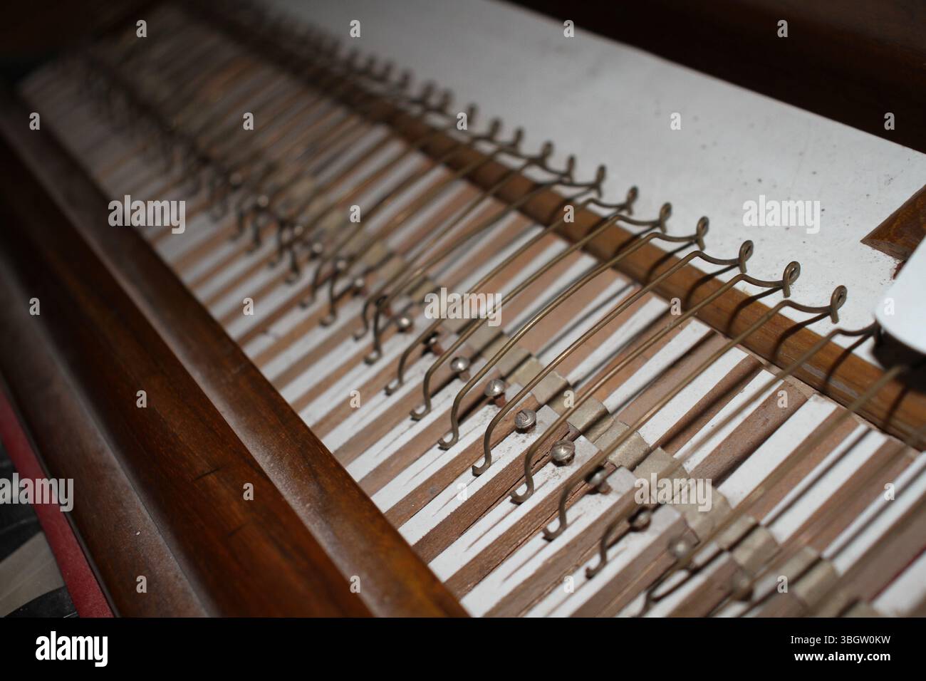 Eine Nahaufnahme des inneren Mechanismus einer Harmoniumtastatur. Die Holzhämmer und die Hebel sind im Inneren des Instruments sichtbar. Stockfoto