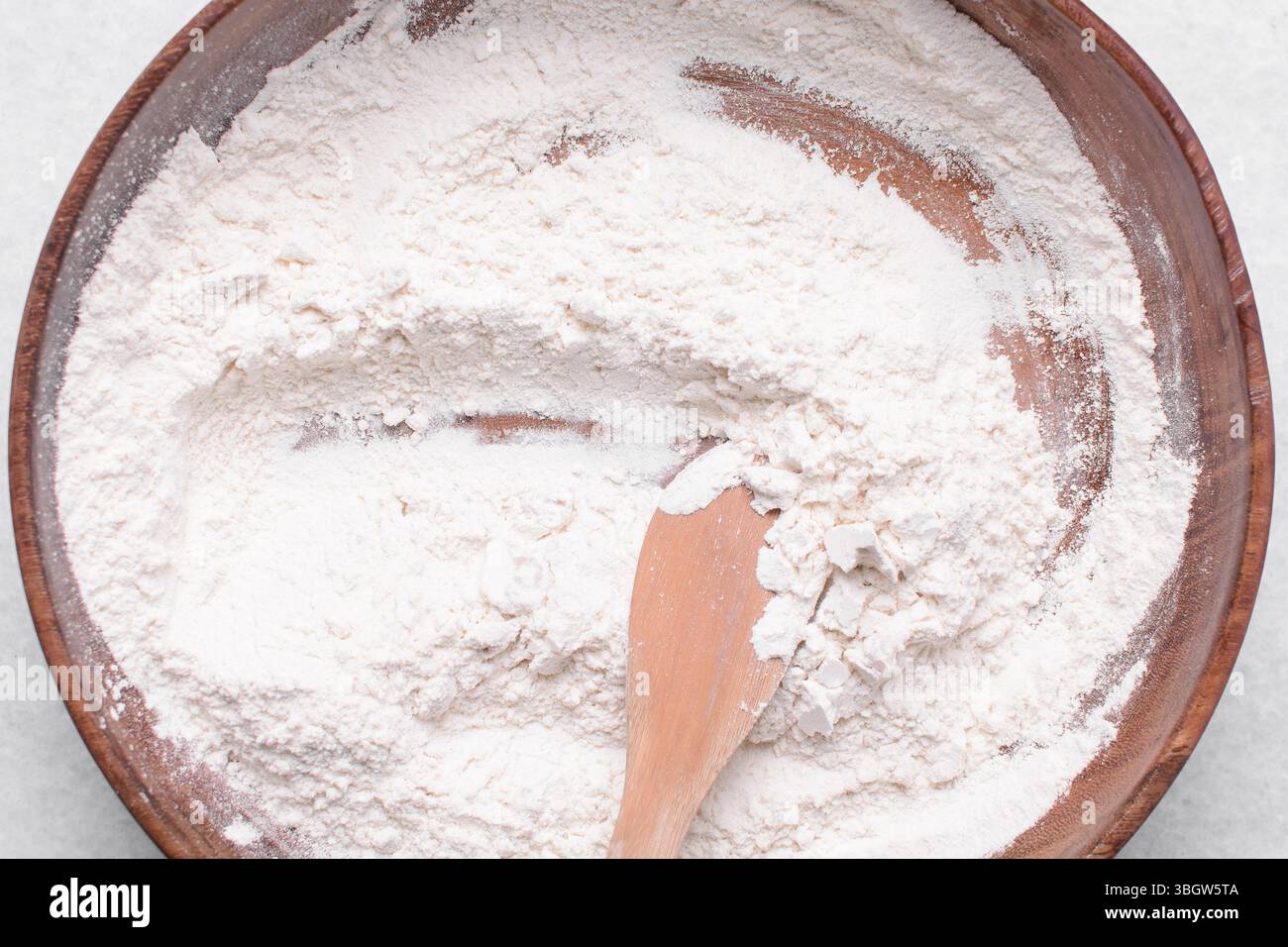 Draufsicht auf Allzweckmehl in einer Schüssel, Draufsicht auf Backmehl auf einer weißen Arbeitsplatte Stockfoto