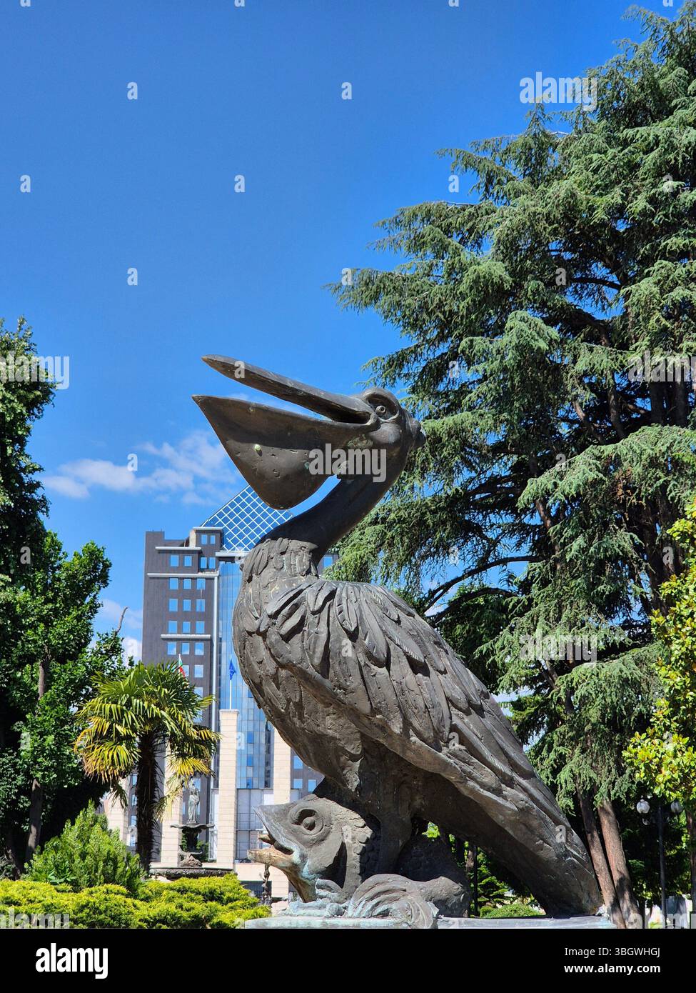 Statue eines Pelikans über einem Fisch im Park - Smartphone-aufgenommenes Stockfoto